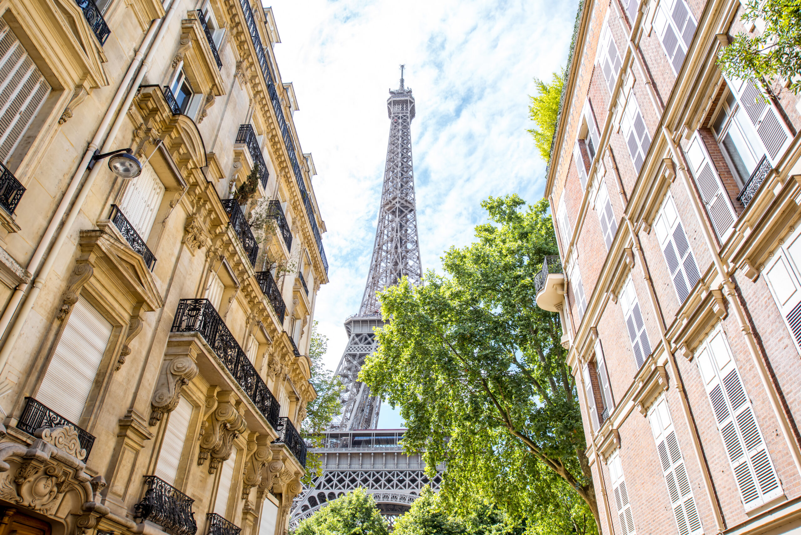 View from below on the beautiful buildings and Eiffel tower during the sunny weather in Paris