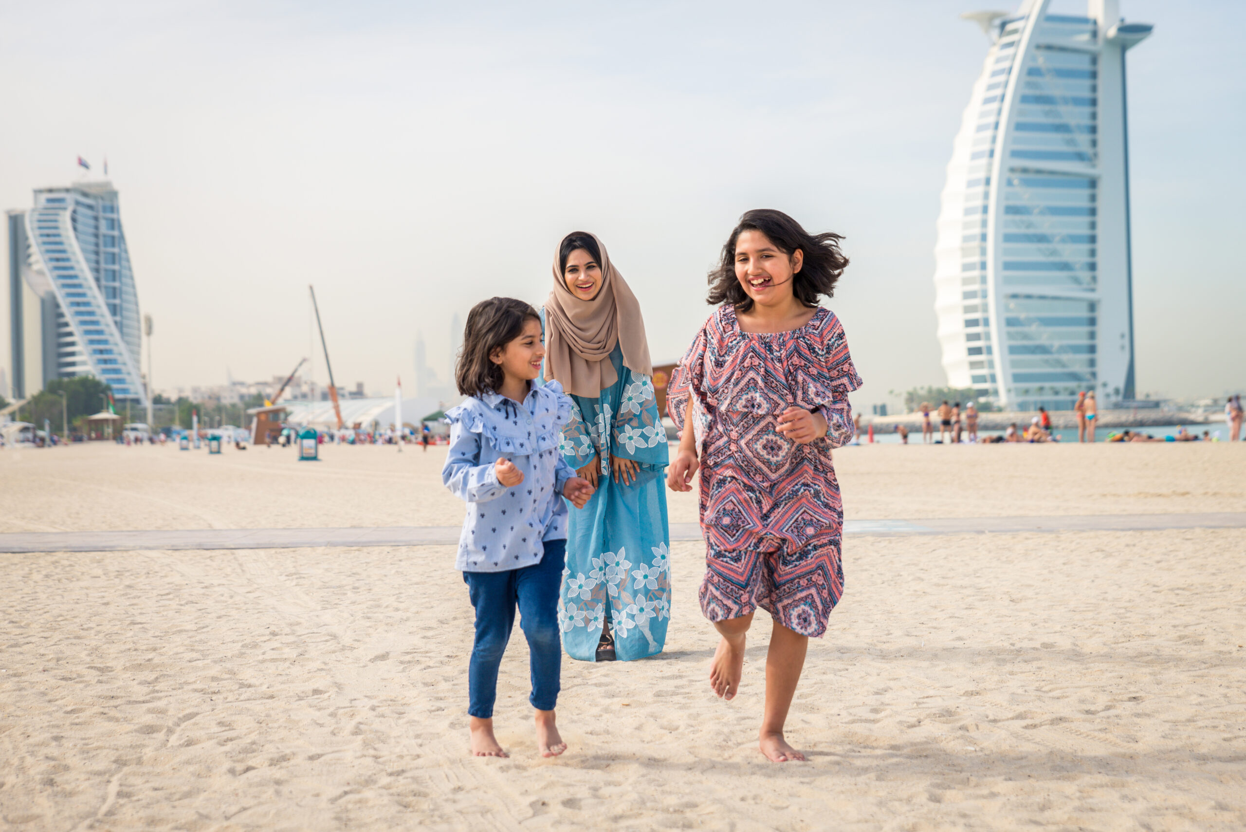 Happy arabian family having fun in Dubai - Mom together with her daughters on the beach