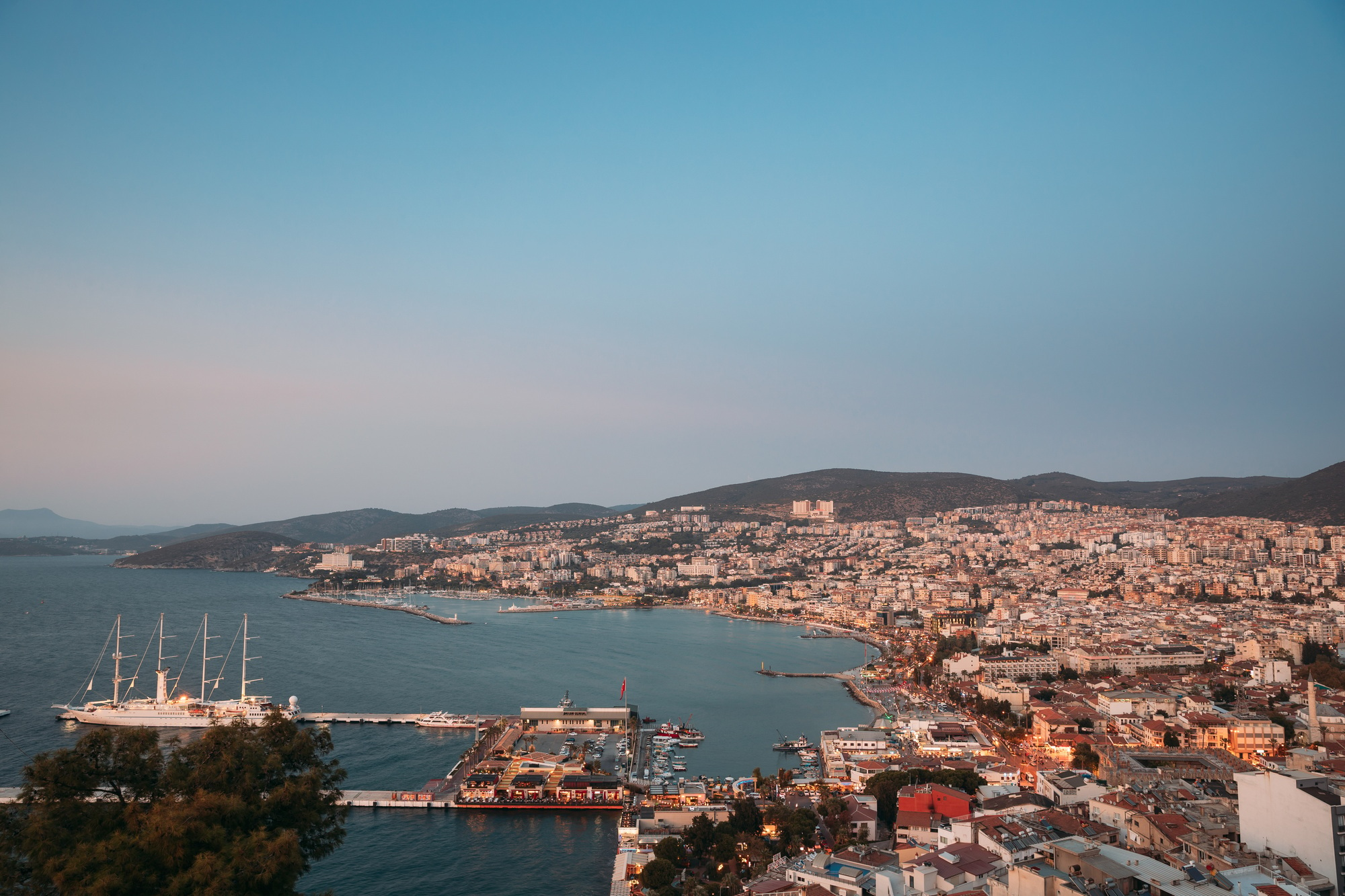 Kusadasi, Aydin Province, Turkey. Waterfront And Kusadasi Cityscape In Summer Evening. Scenic View