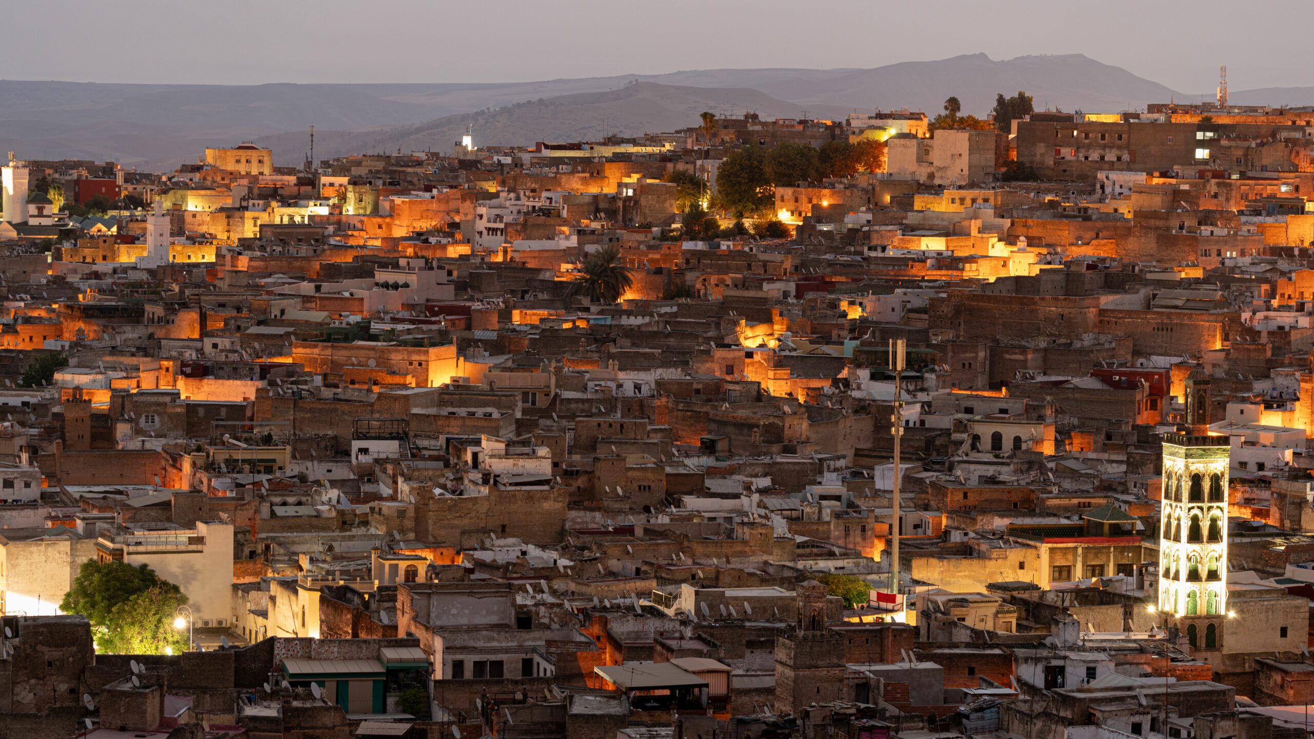 The city of Fez illuminated by early morning light, showcasing historic buildings and structures.